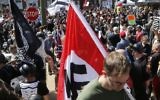 Illustrative: A white supremacist carrying a Nazi flag into Emancipation Park in Charlottesville, Virginia, on August 12, 2017. (AP/Steve Helber/File)