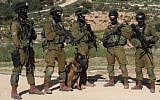 Illustrative photo of IDF soldiers with a trained army dog during a drill, April 2, 2014. (Gershon Elinson/Flash 90)