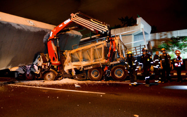 Rescue workers and police at the scene of a pedestrian bridge collapse on a truck on Route 4 near Givat Shmuel, August 14, 2017. (Moti Karelitz/Flash90) Rescue workers and police at the scene of a pedestrian bridge collapse on a truck on Route 4 near Givat Shmuel, August 14, 2017. (Moti Karelitz/Flash90)