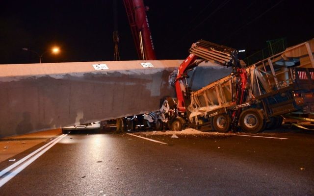 Rescue workers and police at the scene where part of a pedestrian bridge collapsed on a truck on Highway 4 near Givat Shmuel, August 14, 2017. (Moti arelitz/Flash90) Rescue workers and police at the scene where part of a pedestrian bridge collapsed on a truck on Highway 4 near Givat Shmuel, August 14, 2017. (Moti arelitz/Flash90)