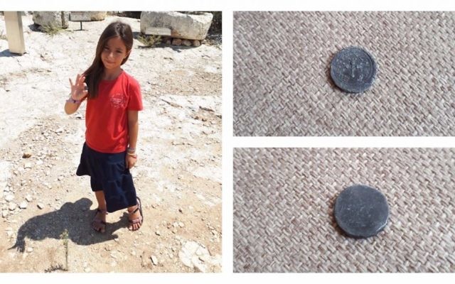 8-year-old Hallel Halevy holding her find of a rare 2,00-year-old half-shekel coin on August 23, 2017 in Halamish. (courtesy)