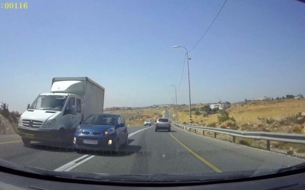 The blue vehicle attempts to pass the white truck by merging into the oncoming traffic lane, nearly colliding with the approaching vehicle on Route 60 in the West Bank. (Courtesy: Avraham Binyamin) The blue vehicle attempts to pass the white truck by merging into the oncoming traffic lane, nearly colliding with the approaching vehicle on Route 60 in the West Bank. (Courtesy: Avraham Binyamin)