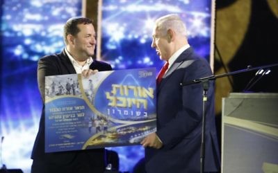 Prime Minister Benjamin Netanyahu (r) with settler leader Yossi Dagan at event commemorating 50 years of settlement in the West Bank, August 28, 2017. (Jacob Magid/Times of Israel)