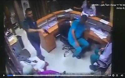 A patient's relative draws a gun in the emergency department of a Jenin hospital, August 1, 2017. (Screenshot)