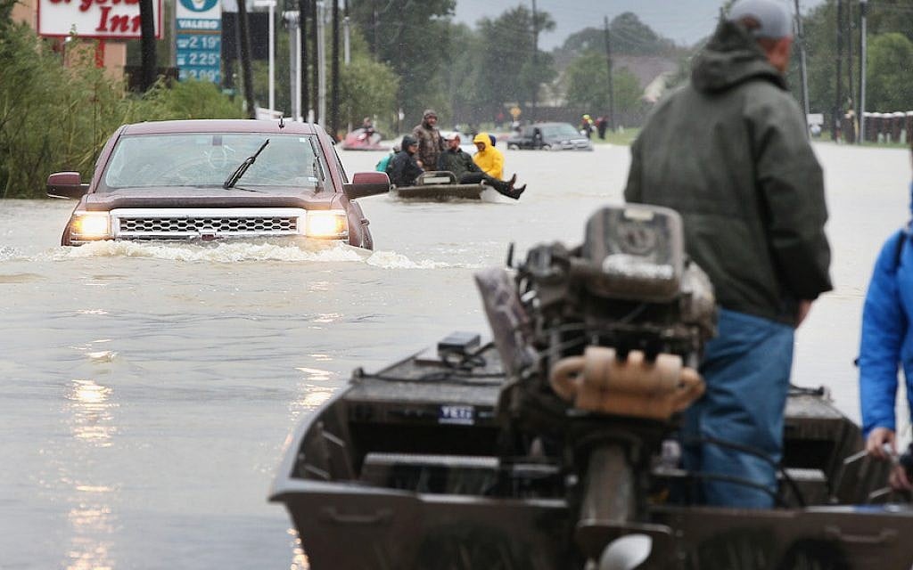 Rescue workers and volunteers help residents make their way out of a flooded neighborhood after it was inundated with rain water following Hurricane Harvey on August 29, 2017 in Houston, Texas. (Scott Olson/Getty Images via JTA) Rescue workers and volunteers help residents make their way out of a flooded neighborhood after it was inundated with rain water following Hurricane Harvey on August 29, 2017 in Houston, Texas. (Scott Olson/Getty Images via JTA)