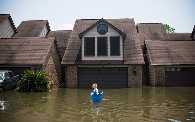 Jenna Fountain carries a bucket down Regency Drive to try to recover items from their flooded home in Port Arthur, Texas, September 1, 2017. (AFP PHOTO/ Emily Kask) Jenna Fountain carries a bucket down Regency Drive to try to recover items from their flooded home in Port Arthur, Texas, September 1, 2017. (AFP PHOTO/ Emily Kask)