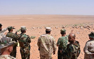 Syrian government forces look at the horizon from a hill in Bir Qabaqib, more than 40 kilometers west of Deir Ezzor, after taking control of the area on their way to Kobajjep in the ongoing battle against Islamic State group jihadists, September 4, 2017. (AFP/George OURFALIAN)