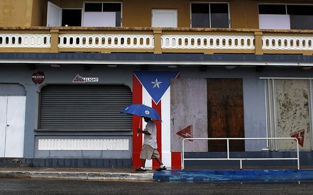 A man with an umbrella walks on a sidewalk as Hurricane Irma approaches in Luquillo, Puerto Rico, on September 6, 2017. (AFP Photo/Ricardo Arduengo) A man with an umbrella walks on a sidewalk as Hurricane Irma approaches in Luquillo, Puerto Rico, on September 6, 2017. (AFP Photo/Ricardo Arduengo)