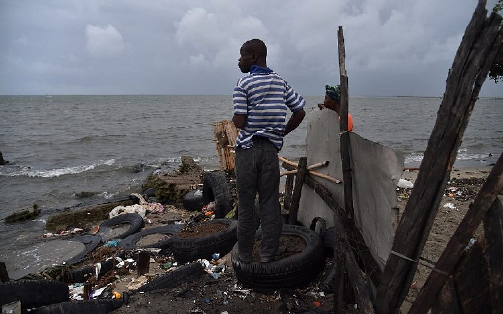 Jean looks at the sea from a house where he is working in the neighborhood of Aviation in Cap-Haitien, Haiti, on September 7, 2017. Hurricane Irma is barreling past Haiti towards the Turks and Caicos Islands, and then the Bahamas. (AFP Photo/Hector Retamal)