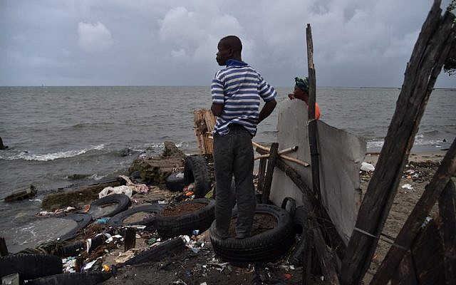 Jean looks at the sea from a house where he is working in the neighborhood of Aviation in Cap-Haitien, Haiti, on September 7, 2017. Hurricane Irma is barreling past Haiti towards the Turks and Caicos Islands, and then the Bahamas. (AFP Photo/Hector Retamal)