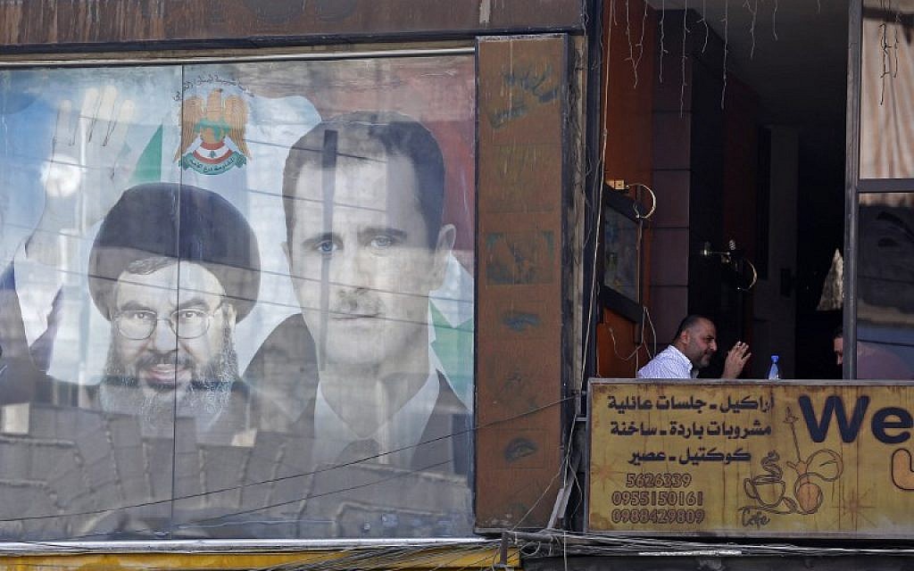 A poster bearing an image of Syrian President Bashar Assad (R) and Hezbollah leader Hassan Nasrallah is seen in Damascus on September 7, 2017. (AFP/Louai Beshara) A poster bearing an image of Syrian President Bashar Assad (R) and Hezbollah leader Hassan Nasrallah is seen in Damascus on September 7, 2017. (AFP/Louai Beshara)