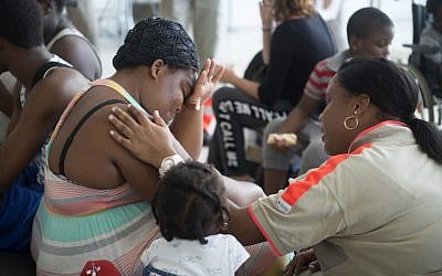 A member of the French Red Cross comforts a woman, who was evacuated from the island of Saint Martin that has been ravaged by Hurricane Irma, upon her arrival on September 9, 2017 at the Pole Caraibes international airport in Pointe-a-Pitre on the French Caribbean island of Guadeloupe.(AFP PHOTO / Helene Valenzuela)