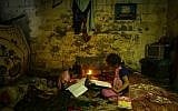 Illustrative: Palestinian children do their homework by candlelight during a power outage in Gaza City on September 11, 2017. (AFP Photo/Mahmud Hams)