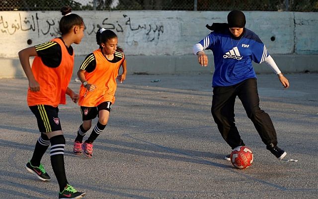 Palestinian sports teacher Rajaa Hamdan (R) leads a football training session with young girls in the northern West Bank village of Deir Jarir, near Ramallah, on September 13, 2017. (AFP PHOTO / ABBAS MOMANI) Palestinian sports teacher Rajaa Hamdan (R) leads a football training session with young girls in the northern West Bank village of Deir Jarir, near Ramallah, on September 13, 2017. (AFP PHOTO / ABBAS MOMANI)