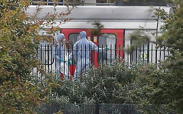 Police forensics officers works next to an underground train at a platform at Parsons Green underground station in west London on September 15, 2017, following an explosion, later claimed by Islamic State, which injured 29 people. (AFP/Daniel Leal-Olivas)