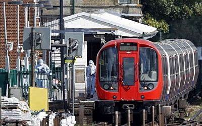 Police forensics officers works alongside an underground tube train at a platform at Parsons Green underground tube station in west London on September 15, 2017 following an explosion. (AFP/Adrian Dennis)
