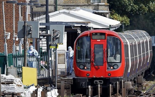 Police forensics officers works alongside an underground tube train at a platform at Parsons Green underground tube station in west London on September 15, 2017 following an explosion. (AFP/Adrian Dennis)