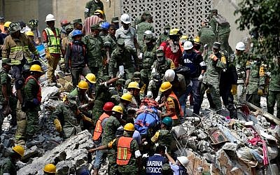 A man is pulled out of the rubble alive in Mexico City on September 20, 2017 as the search for survivors continues a day after a strong quake hit central Mexico. 
(AFP PHOTO / Pedro PARDO)