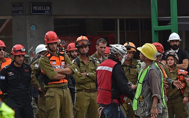 Israeli rescuers (olive green and black) take part in the search for survivors in a flattened building in Mexico City on September 21, 2017 two days after a strong quake hit central Mexico. (AFP/ Yuri CORTEZ)