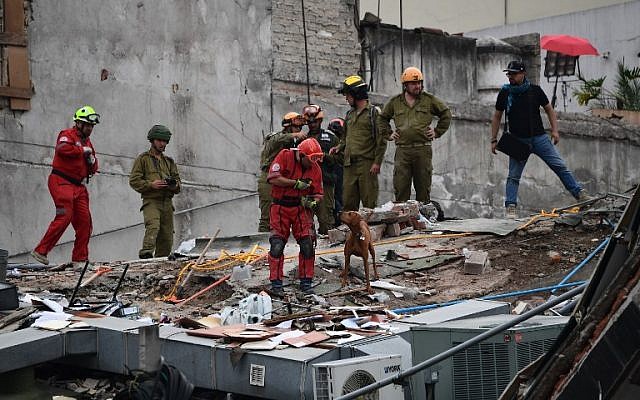 Rescuers from Israel (in olive green) join the search for survivors in a flattened building in Mexico City on September 21, 2017 two days after a strong quake hit central Mexico. (AFP/Ronaldo Schemidt)