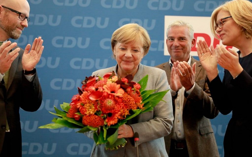 German Chancellor Angela Merkel (2nd L) holds a bouquet of flowers as she is applauded by members of the CDU as she arrives for a meeting with the party's leadership in Berlin on September 25, 2016. (AFP Photo/Odd Andersen) German Chancellor Angela Merkel (2nd L) holds a bouquet of flowers as she is applauded by members of the CDU as she arrives for a meeting with the party's leadership in Berlin on September 25, 2016. (AFP Photo/Odd Andersen)