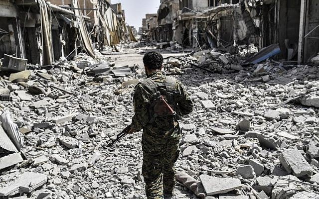 A member of the Syrian Democratic Forces (SDF) sprints through the debris in the old city center on the eastern frontline of Raqqa on September 25, 2017. (AFP PHOTO/BULENT KILIC) A member of the Syrian Democratic Forces (SDF) sprints through the debris in the old city center on the eastern frontline of Raqqa on September 25, 2017. (AFP PHOTO/BULENT KILIC)