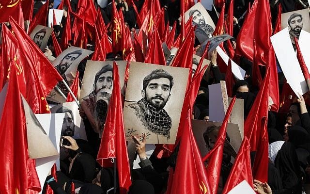 Mourners raise portraits of Mohsen Hojaji, a young member of Iran's elite revolutionary guards Corps (IRGC) who was beheaded in Syria by Islamic State (IS) group fighters, during a funerary procession for him at Imam Hossein Square in the capital Tehran on September 27, 2017. (AFP PHOTO / ATTA KENARE) Mourners raise portraits of Mohsen Hojaji, a young member of Iran's elite revolutionary guards Corps (IRGC) who was beheaded in Syria by Islamic State (IS) group fighters, during a funerary procession for him at Imam Hossein Square in the capital Tehran on September 27, 2017. (AFP PHOTO / ATTA KENARE)