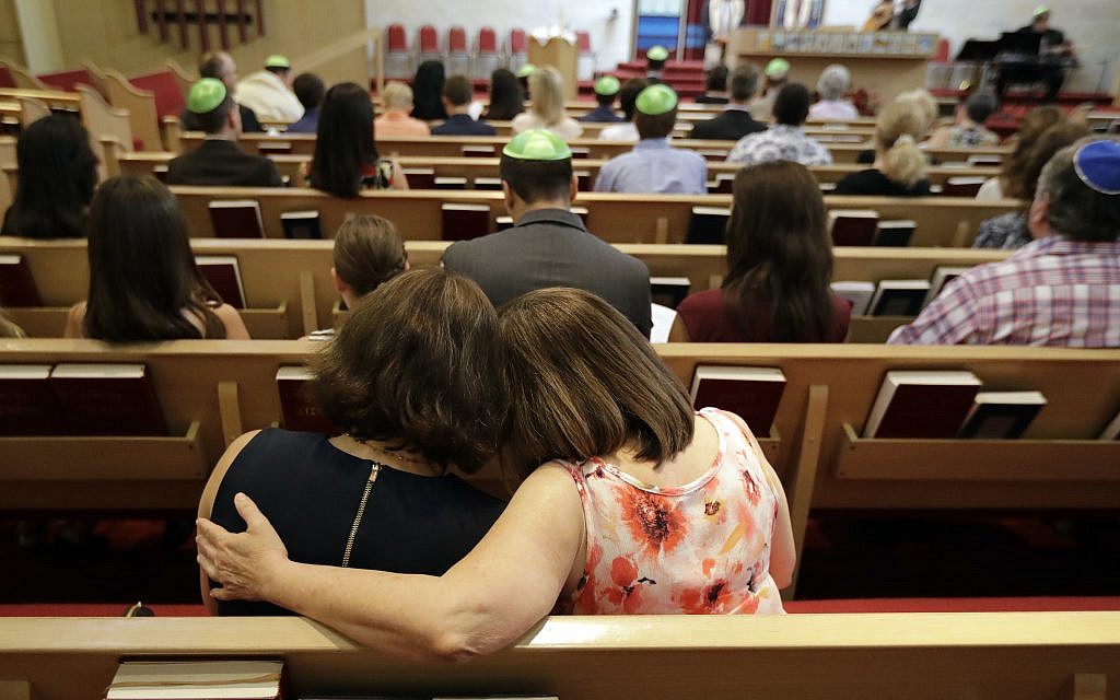 Debbie Uzick, right, puts her arm around Natalie Hausman-Weiss during a Bar Mitzvah on Saturday, Sept. 2, 2017, in Houston. Both of their homes were flooded in the aftermath of Harvey. (AP Photo/David J. Phillip)