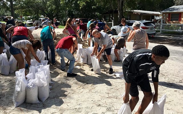 Joseph, Jr. (R) of St. Petersburg, bends down to carry sandbags to his family's vehicle at Lealman Community Park, in St. Petersburg, Florida, September 5, 2017, as residents prepare for Hurricane Irma. (Lara Cerri/Tampa Bay Times via AP) Joseph, Jr. (R) of St. Petersburg, bends down to carry sandbags to his family's vehicle at Lealman Community Park, in St. Petersburg, Florida, September 5, 2017, as residents prepare for Hurricane Irma. (Lara Cerri/Tampa Bay Times via AP)