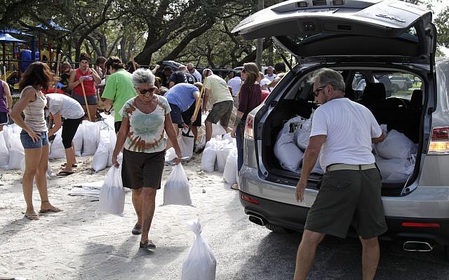 Helen Conklin carries sandbags as her husband, John Conklin, loads the car at Lealman Community Park, 3890 55th Ave. N. in St. Petersburg, September 5, 2017. (Lara Cerri/The Tampa Bay Times via AP)