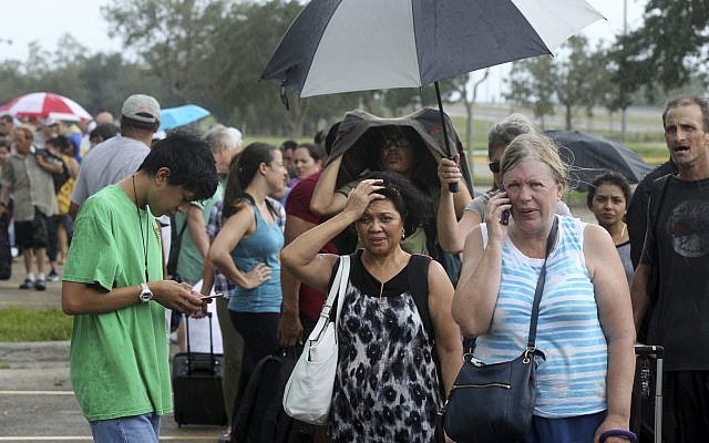 Evacuees stand in line to enter the Germain Arena, which is being used as a fallout shelter, in advance of Hurricane Irma, in Estero, Fla., Saturday, Sept. 9, 2017.  (AP Photo/Gerald Herbert)