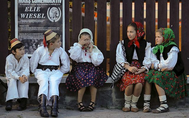 Children wearing traditional outfits wait before a march marking one year since the death of Nobel laureate and Holocaust survivor Elie Wiesel in Sighetu Marmatiei, northern Romania, Sunday, September 10, 2017. (AP Photo/Vadim Ghirda) Children wearing traditional outfits wait before a march marking one year since the death of Nobel laureate and Holocaust survivor Elie Wiesel in Sighetu Marmatiei, northern Romania, Sunday, September 10, 2017. (AP Photo/Vadim Ghirda)
