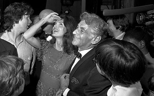 In this Monday, June 5, 1972 file photo Jacqueline Kennedy Onassis, center left, stands with conductor-composer Leonard Bernstein, center right, as she shields light from her eyes while looking up at the stage in the John F. Kennedy Center for the Performing Arts, in Washington. (AP Photo, File)