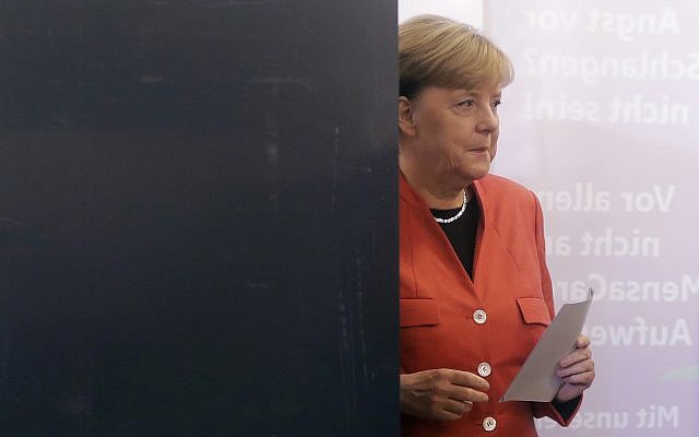 German Chancellor Angela Merkel leaves the election booth as she casts her vote in Berlin, Germany, September 24, 2017. (AP Photo/Markus Schreiber)