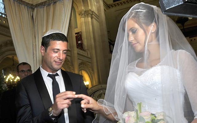 Illustrative: A Jewish couple stand underneath the 'chuppah' during their wedding in a synagogue in Paris, France, July 21, 2013. (Serge Attal/Flash90/via JTA) Illustrative: A Jewish couple stand underneath the 'chuppah' during their wedding in a synagogue in Paris, France, July 21, 2013. (Serge Attal/Flash90/via JTA)