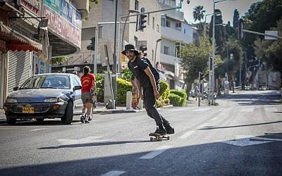 A skateboarder rides down in empty street in Haifa during Yom Kippur on September 30, 2017. (Noam Revkin Fenton/Flash90)