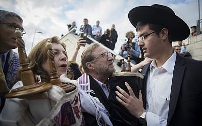Orthodox Jews try to prevent a group of American Conservative and Reform rabbis and the Women of the Wall movement members from bringing Torah scrolls into the Western Wall compound during a protest march against the government’s failure to deliver a new prayer space, at the Western Wall in Jerusalem Old City, November 2, 2016. (Hadas Parush/Flash90)