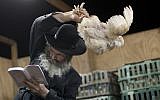 Illustrative image of an ultra-Orthodox Jewish man in a religious neighborhood in Ashdod performing 'kapparot' ritual before Yom Kippur. (Dima Vazinovich/Flash90)