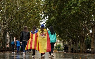Girls stroll through the center of Figueras with the Spanish and a pro-independence 'Estelada' Catalan flag on September 30, 2017 in Figueras (AFP PHOTO / CESAR MANSO)