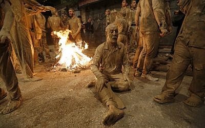 Iranian Shiite Muslims sit after rubbing mud on their body during the 'Kharrah Mali' (Mud Rubbing) ritual to mark the Ashura religious ceremony in the city of Khorramabad, some 470 kms southwest of Tehran, early in the morning on October 1, 2017. (Atta Kenare/AFP)