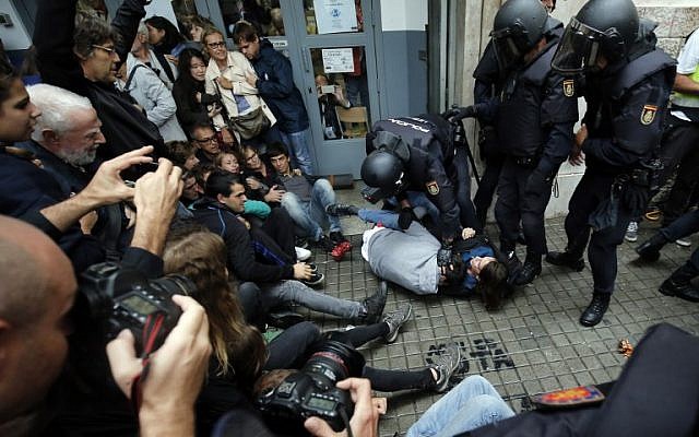 Spanish police officers immobilize some people outside a polling station in Barcelona, on October 1, 2017, on the day of a referendum on independence for Catalonia banned by Madrid.

More than 5.3 million Catalans are called today to vote in a referendum on independence, surrounded by uncertainty over the intention of Spanish institutions to prevent this plebiscite banned by justice.
 / AFP PHOTO / PAU BARRENA