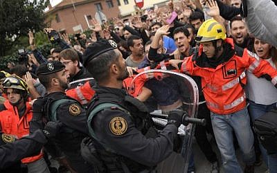 Firemen try to hold a group of people outside a polling station in San Julia de Ramis, on October 1, 2017, on the day of a referendum on independence for Catalonia banned by Madrid. (AFP PHOTO / LLUIS GENE)