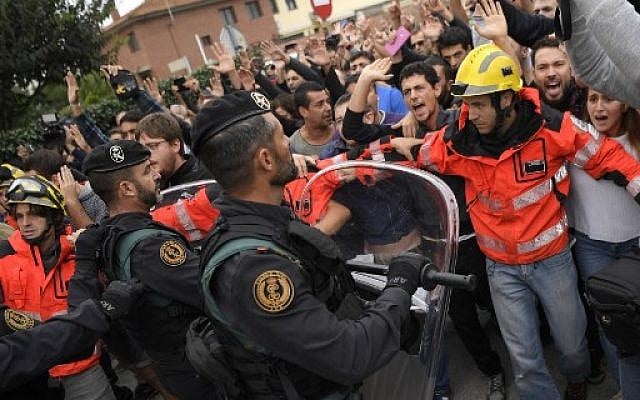 Firemen try to hold a group of people outside a polling station in San Julia de Ramis, on October 1, 2017, on the day of a referendum on independence for Catalonia banned by Madrid. (AFP PHOTO / LLUIS GENE) Firemen try to hold a group of people outside a polling station in San Julia de Ramis, on October 1, 2017, on the day of a referendum on independence for Catalonia banned by Madrid. (AFP PHOTO / LLUIS GENE)