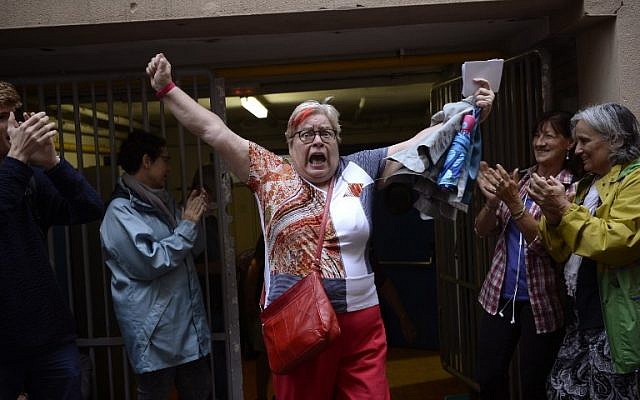 A woman celebrates outside a polling station after casting her vote in Barcelona, on October 01, 2017, in a referendum on independence for Catalonia banned by Madrid. (AFP PHOTO / Josep LAGO)