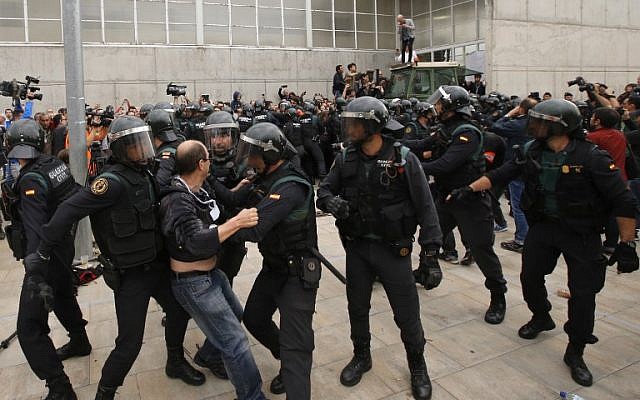 A man clashes with Spanish Guardia Civil guards outside a polling station in Sant Julia de Ramis, where the Catalan president was supposed to vote, on October 1, 2017, the day of a referendum on independence for Catalonia banned by Madrid. (AFP PHOTO / Raymond ROIG) A man clashes with Spanish Guardia Civil guards outside a polling station in Sant Julia de Ramis, where the Catalan president was supposed to vote, on October 1, 2017, the day of a referendum on independence for Catalonia banned by Madrid. (AFP PHOTO / Raymond ROIG)