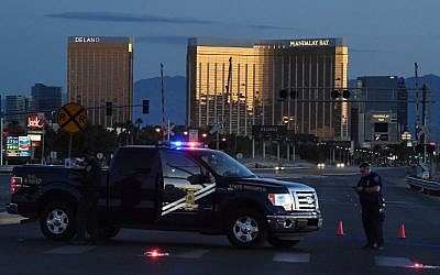 Police form a perimeter around the road leading to the Mandalay Hotel (background) after a gunman killed at least 59 people and wounded more than 500 others when he opened fire on a country music concert in Las Vegas, Nevada on October 2, 2017.  (AFP/ Mark Ralston)