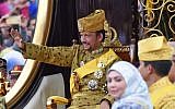 Brunei's Sultan Hassanal Bolkiah (L) waves from the royal chariot during a procession to mark his golden jubilee of accession to the throne in Bandar Seri Begawan on October 5, 2017. (Roslan Rahman/AFP)