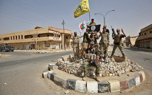 Members of the Iraqi armed forces backed by paramilitary fighters from the Popular Mobilization Forces pose for a photograph in Hawija on October 5, 2017, after retaking the city from the Islamic State terror group. (AFP Photo/Ahmad Al-Rubaye) Members of the Iraqi armed forces backed by paramilitary fighters from the Popular Mobilization Forces pose for a photograph in Hawija on October 5, 2017, after retaking the city from the Islamic State terror group. (AFP Photo/Ahmad Al-Rubaye)