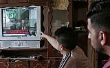 Palestinians watch on TV the signing of a reconciliation deal in Cairo between rival Palestinian factions Hamas and Fatah on October 12, 2017, in Rafah in the southern Gaza Strip. (Said Khatib/AFP)