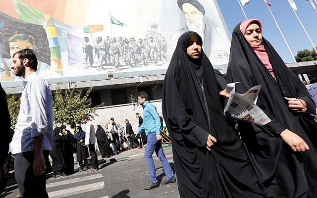 Iranian women walk past a portrait of late Iranian supreme leader Ayatollah Ruhollah Khomeini (top R) following the weekly Friday prayer in Tehran on October 13, 2017. (AFP PHOTO / STR) Iranian women walk past a portrait of late Iranian supreme leader Ayatollah Ruhollah Khomeini (top R) following the weekly Friday prayer in Tehran on October 13, 2017. (AFP PHOTO / STR)